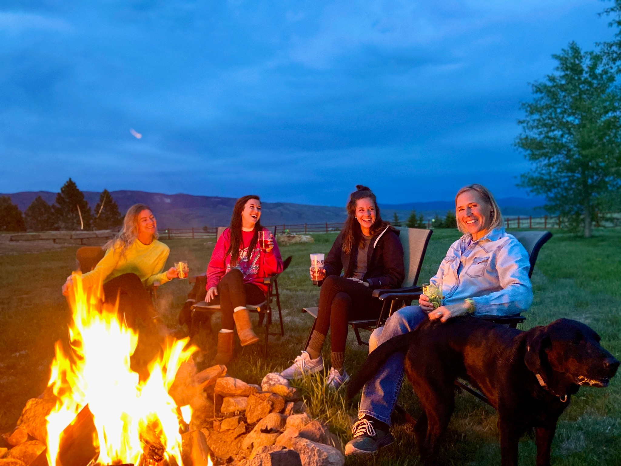 Family and friends laughing around a campfire at Two Dog Ranch