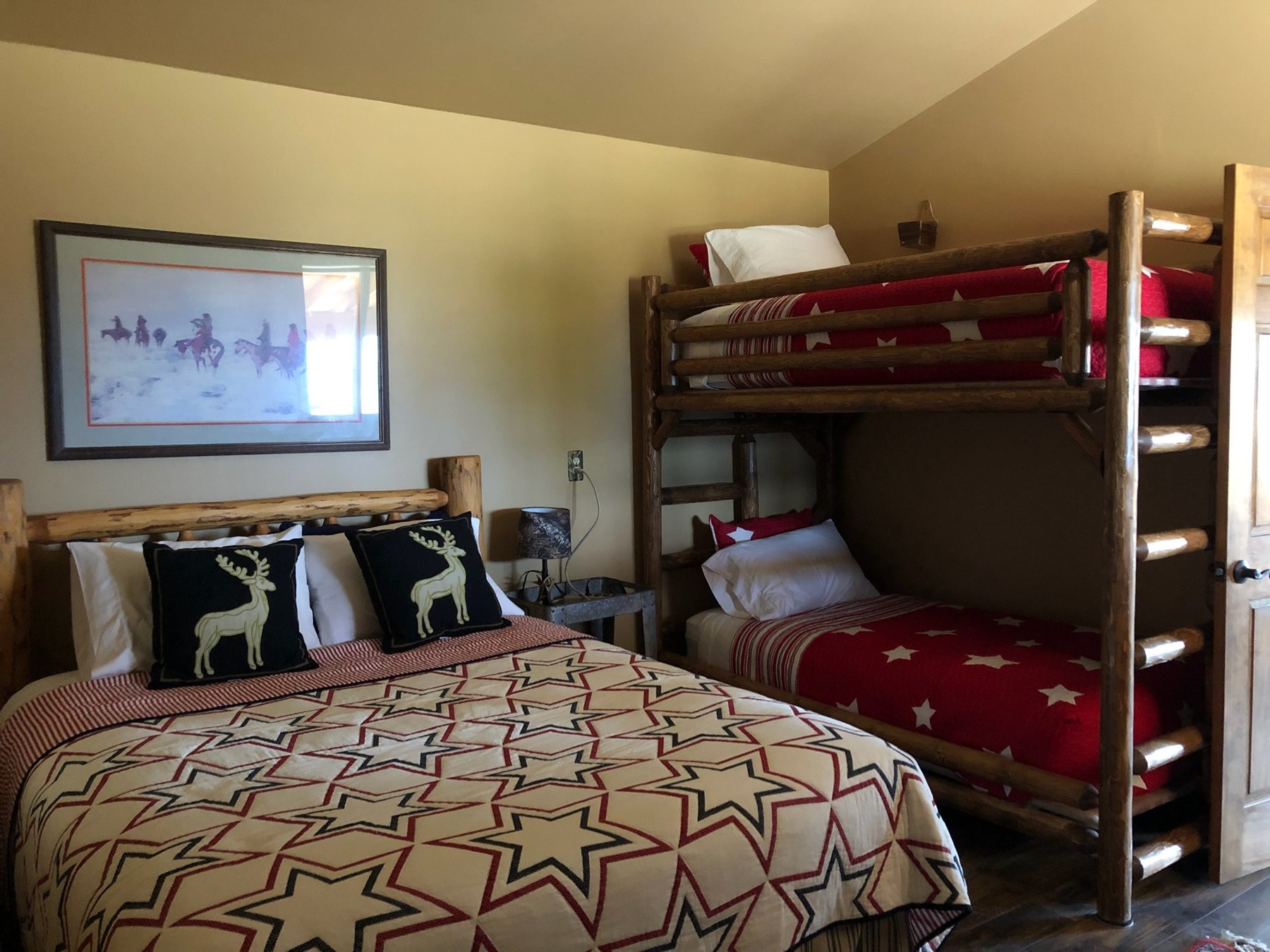 Bedroom in the bunkhouse with queen bed and bunk beds