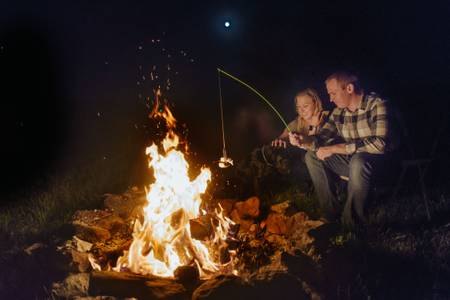 Guests sitting by the campfire at night