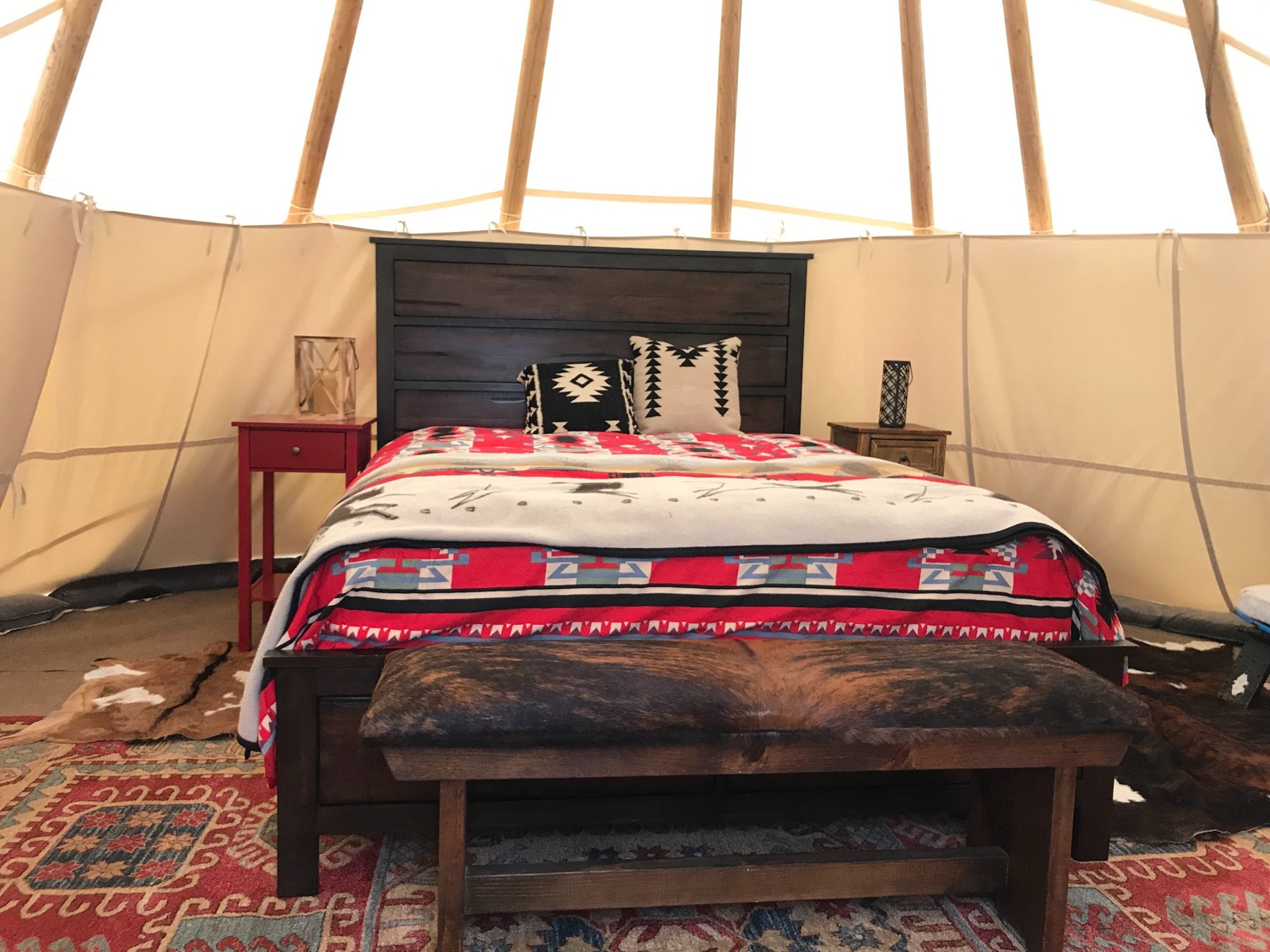 Queen bed inside the furnished tipi at Two Dog Ranch